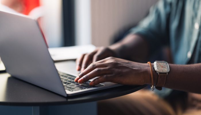 Hands type on a laptop